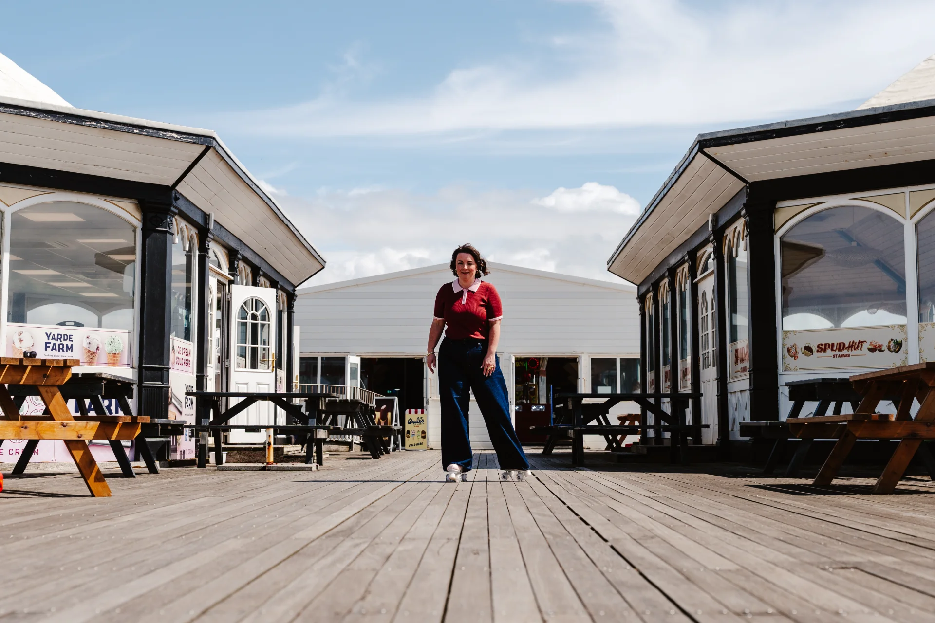 Hannah McLachlan walking along a bright coastal promenade